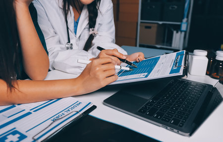 Group of doctors attending seminar in hospital lecture hall with senior physician giving medical presentation and professional training session on healthcare practicesの写真素材