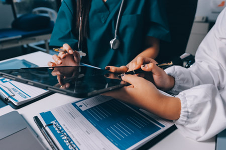 Group of doctors attending seminar in hospital lecture hall with senior physician giving medical presentation and professional training session on healthcare practicesの写真素材