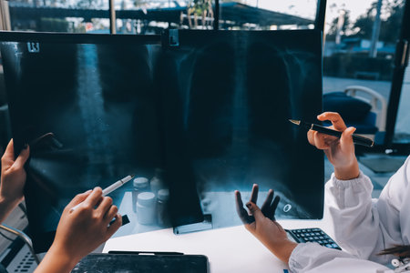 Group of doctors attending seminar in hospital lecture hall with senior physician giving medical presentation and professional training session on healthcare practicesの写真素材