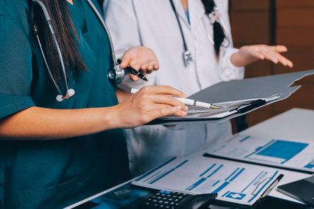 Group of doctors attending seminar in hospital lecture hall with senior physician giving medical presentation and professional training session on healthcare practicesの写真素材