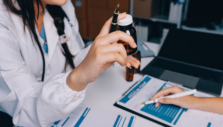 Group of doctors attending seminar in hospital lecture hall with senior physician giving medical presentation and professional training session on healthcare practicesの写真素材