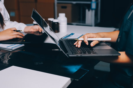 Group of doctors attending seminar in hospital lecture hall with senior physician giving medical presentation and professional training session on healthcare practicesの写真素材