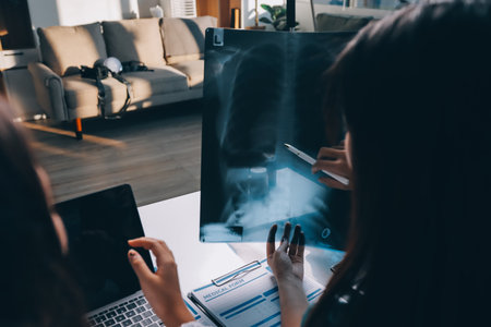 Group of doctors attending seminar in hospital lecture hall with senior physician giving medical presentation and professional training session on healthcare practicesの写真素材