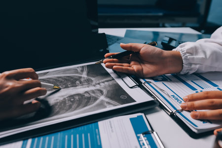 Group of doctors attending seminar in hospital lecture hall with senior physician giving medical presentation and professional training session on healthcare practicesの写真素材