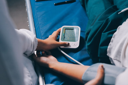 Nurse measuring blood pressure of elderly woman at table, closeup. Assisting senior generation