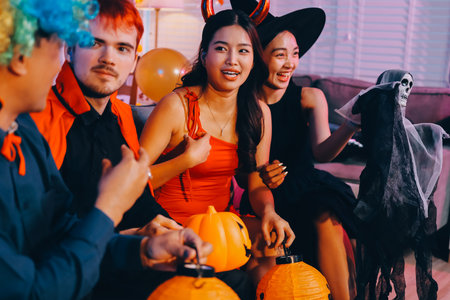 Joyful Halloween party with coworkers in costumes, celebrating with drinks and laughter, fostering teamwork and festive spiritの写真素材