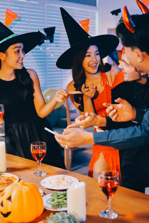 Joyful office Halloween party with coworkers in costumes, celebrating with drinks and laughter, fostering teamwork and festive spiritの写真素材