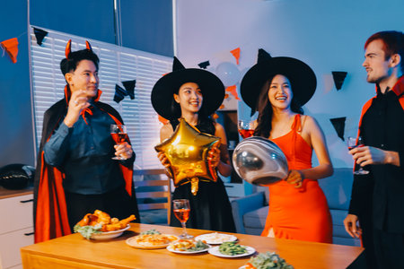 Joyful office Halloween party with coworkers in costumes, celebrating with drinks and laughter, fostering teamwork and festive spiritの写真素材