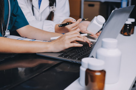 Group of doctors attending seminar in hospital lecture hall with senior physician giving medical presentation and professional training session on healthcare practicesの写真素材