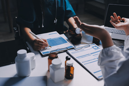 Group of doctors attending seminar in hospital lecture hall with senior physician giving medical presentation and professional training session on healthcare practicesの写真素材