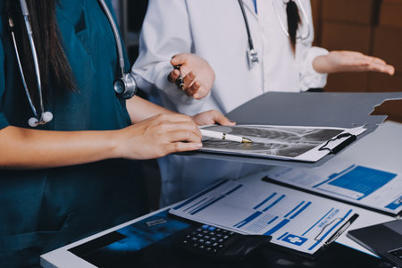 Group of doctors attending seminar in hospital lecture hall with senior physician giving medical presentation and professional training session on healthcare practicesの写真素材
