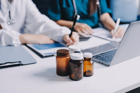 Group of doctors attending seminar in hospital lecture hall with senior physician giving medical presentation and professional training session on healthcare practicesの写真素材