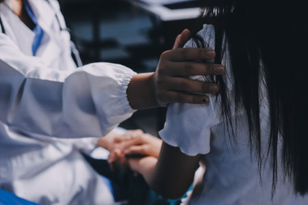 Doctor giving hope. Close up shot of young female physician leaning forward to smiling elderly lady patient holding her hand in palms. Woman caretaker in white coat supporting encouraging old personの写真素材