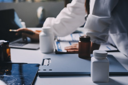 Group of doctors attending seminar in hospital lecture hall with senior physician giving medical presentation and professional training session on healthcare practicesの写真素材