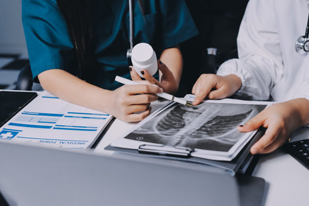 Group of doctors attending seminar in hospital lecture hall with senior physician giving medical presentation and professional training session on healthcare practicesの写真素材