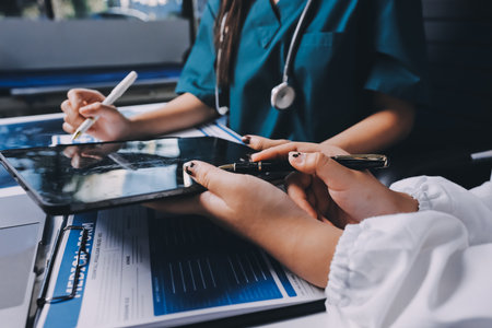 Group of doctors attending seminar in hospital lecture hall with senior physician giving medical presentation and professional training session on healthcare practicesの写真素材