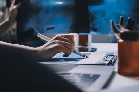 Group of doctors attending seminar in hospital lecture hall with senior physician giving medical presentation and professional training session on healthcare practicesの写真素材