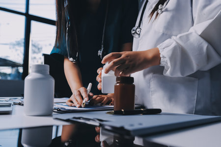 Group of doctors attending seminar in hospital lecture hall with senior physician giving medical presentation and professional training session on healthcare practicesの写真素材