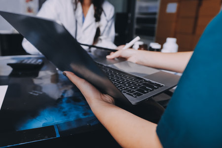 Group of doctors attending seminar in hospital lecture hall with senior physician giving medical presentation and professional training session on healthcare practicesの写真素材