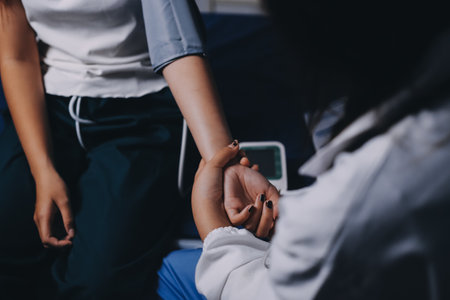 Nurse measuring blood pressure of elderly woman at table, closeup. Assisting senior generationの写真素材