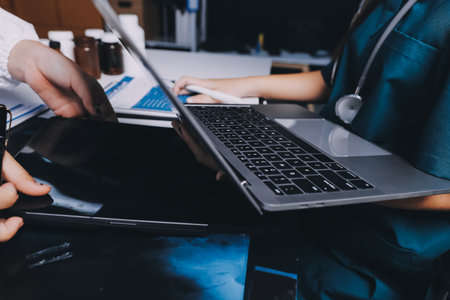 Group of doctors attending seminar in hospital lecture hall with senior physician giving medical presentation and professional training session on healthcare practicesの写真素材