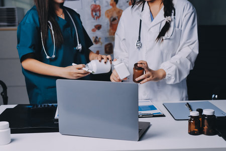 Group of doctors attending seminar in hospital lecture hall with senior physician giving medical presentation and professional training session on healthcare practicesの写真素材