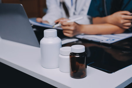 Group of doctors attending seminar in hospital lecture hall with senior physician giving medical presentation and professional training session on healthcare practicesの写真素材
