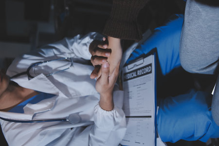 A female nurse caregiver holds hands to encourage and comfort an elderly woman. For care and trust in nursing homes for people of retirement age Caregiver helping elderly woman provides medical adviceの写真素材