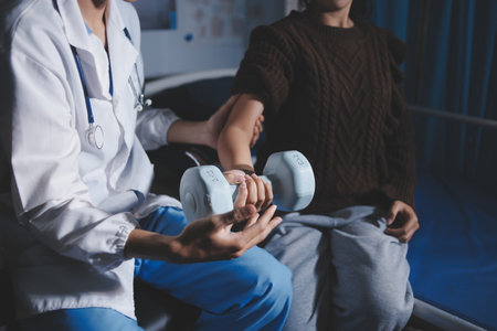 Old woman training with physiotherapist using dumbbells at home. Therapist assisting senior woman with exercises in nursing home. Elderly patient using dumbbells with outstretched arms.の写真素材