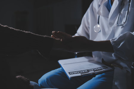 A female nurse caregiver holds hands to encourage and comfort an elderly woman. For care and trust in nursing homes for people of retirement age Caregiver helping elderly woman provides medical adviceの写真素材