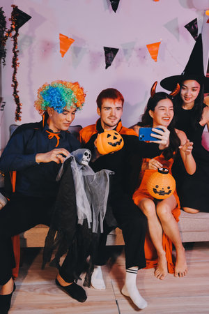 Joyful Halloween party with coworkers in costumes, celebrating with drinks and laughter, fostering teamwork and festive spiritの写真素材