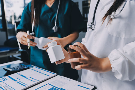 Group of doctors attending seminar in hospital lecture hall with senior physician giving medical presentation and professional training session on healthcare practicesの写真素材