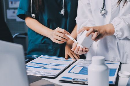 Group of doctors attending seminar in hospital lecture hall with senior physician giving medical presentation and professional training session on healthcare practicesの写真素材