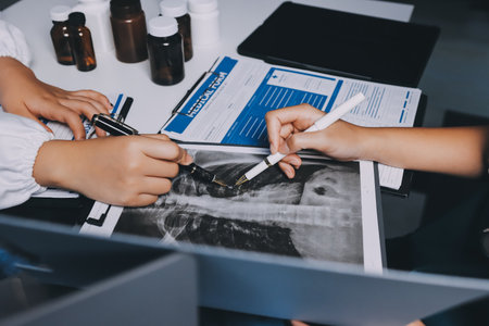 Group of doctors attending seminar in hospital lecture hall with senior physician giving medical presentation and professional training session on healthcare practicesの写真素材