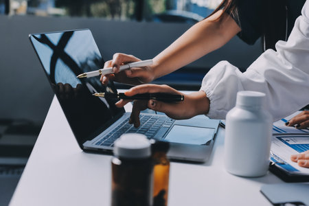 Group of doctors attending seminar in hospital lecture hall with senior physician giving medical presentation and professional training session on healthcare practicesの写真素材