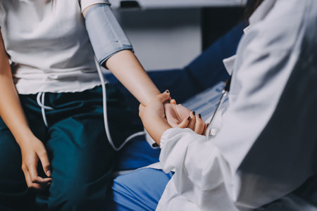 Nurse measuring blood pressure of elderly woman at table, closeup. Assisting senior generation