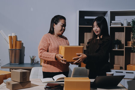 Asian woman describe selling clothes on camera live broadcast on social network at home, Online selling clothes on social media. Blogger woman influencer, SME retail store owner.の写真素材