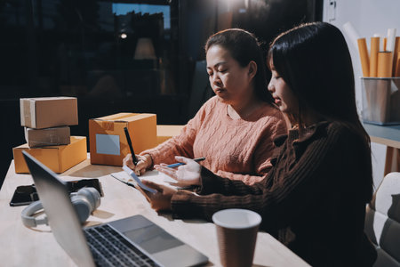 Asian woman selling clothes on camera live broadcast on social network at home. Online selling clothes on social media. Blogger woman influencer, SME retail store owner.の写真素材