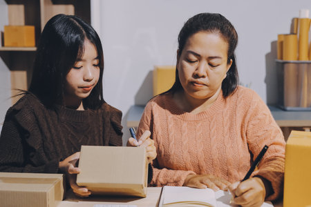 Asian woman selling clothes on camera live broadcast on social network at home, Online selling clothes on social media. Blogger woman influencer, retail store owner.の写真素材