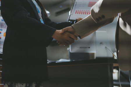 Business people shaking hands in office. Two business partners shaking hands after signing a contract in office.の写真素材