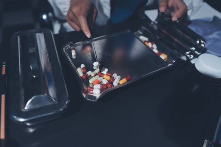 Two doctors and a female nurse meet at a table in the hospital, collaborating on medical tasks using laptops and computersの写真素材