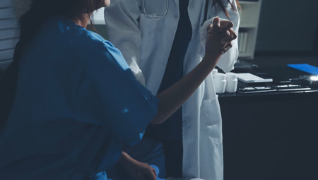 Doctor examining patient's elbow in hospital roomの写真素材