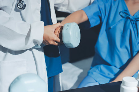 Physical therapist assisting a woman with dumbbell exerciseの写真素材