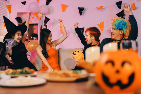 Joyful Halloween party with coworkers in costumes, celebrating with drinks and laughter, fostering teamwork and festive spiritの写真素材