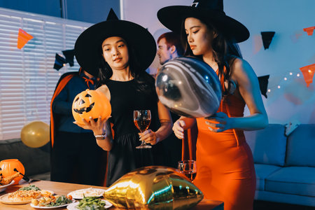 Joyful Halloween party with coworkers in costumes, celebrating with drinks and laughter, fostering teamwork and festive spiritの写真素材