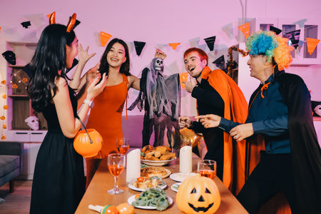 Joyful office Halloween party with coworkers in costumes, celebrating with drinks and laughter, fostering teamwork and festive spiritの写真素材