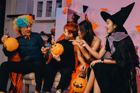 Joyful Halloween party with coworkers in costumes, celebrating with drinks and laughter, fostering teamwork and festive spiritの写真素材