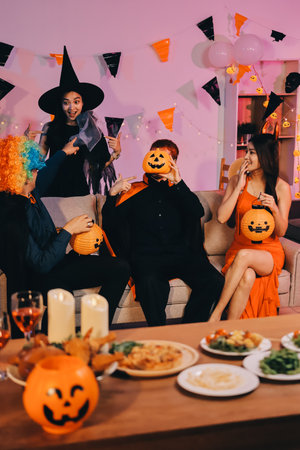 Joyful Halloween party with coworkers in costumes, celebrating with drinks and laughter, fostering teamwork and festive spiritの写真素材