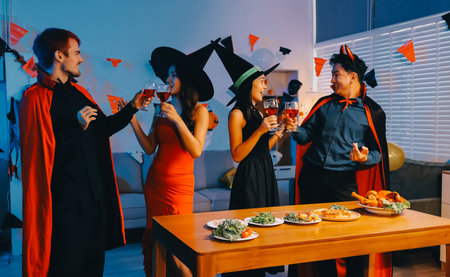 Joyful Halloween party with coworkers in costumes, celebrating with drinks and laughter, fostering teamwork and festive spiritの写真素材