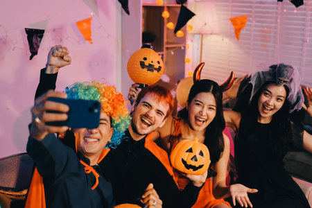 Joyful Halloween party with coworkers in costumes, celebrating with drinks and laughter, fostering teamwork and festive spiritの写真素材